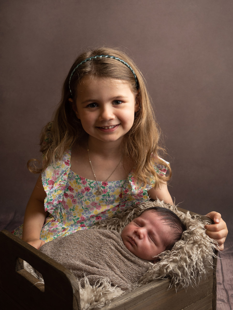 Big sister with her newborn baby brother, photographed at Infinity